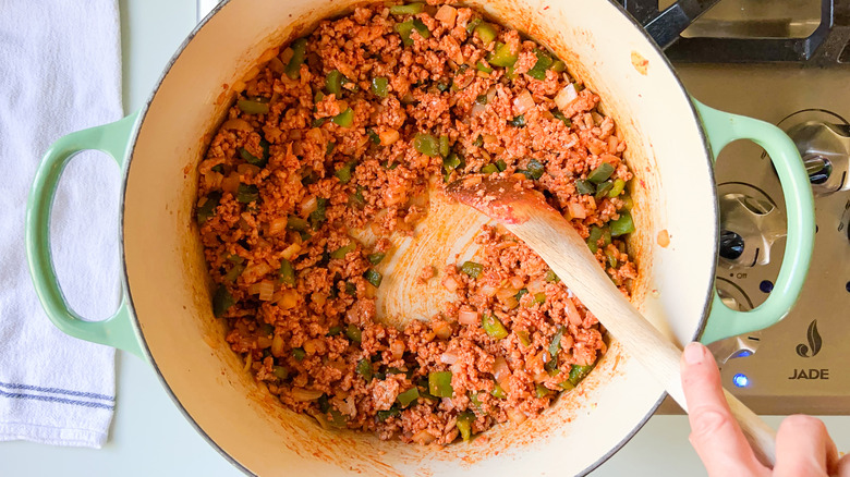 Ground turkey and vegetables with tomato paste in pot 