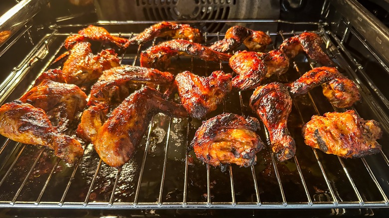 Crispy chicken wings roasting in an oven on a wire rack