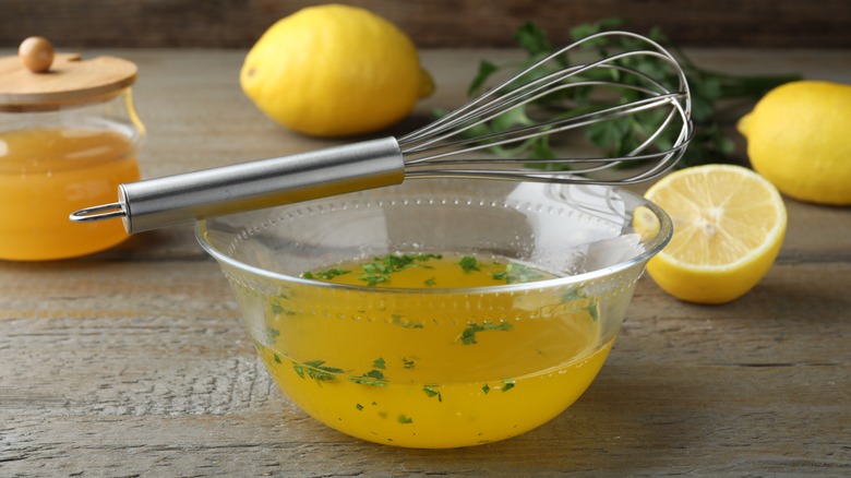 salad dressing with whisk and lemons