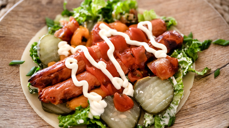 hot dogs on top of a salad