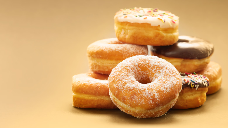 A stack of donuts with a sugar dipped in front.