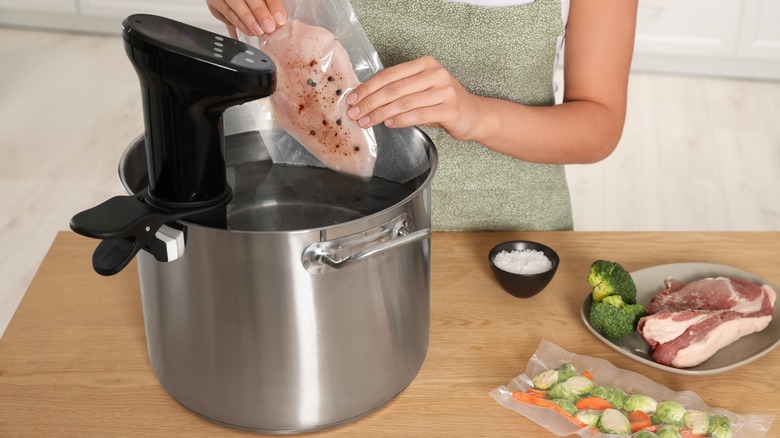 Sous vide bag being placed in pot