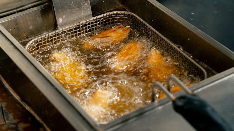 Chicken frying in professional-grade deep fryer