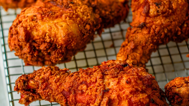 Close up of fried chicken on a metal drying rack