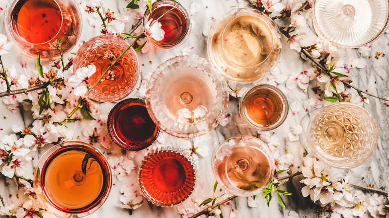 Glasses of wine and flowers on table