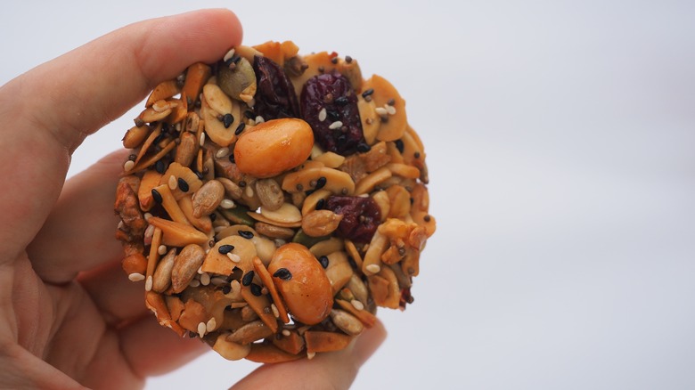 Hand holding a nuts and seeds cookie