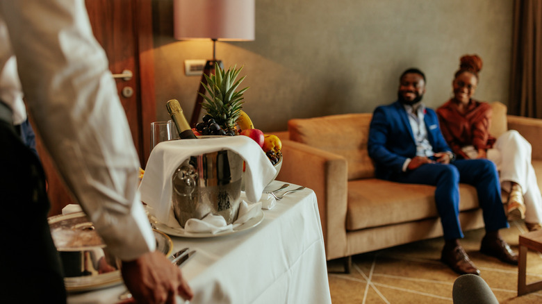 hotel staff delivering room service to couple