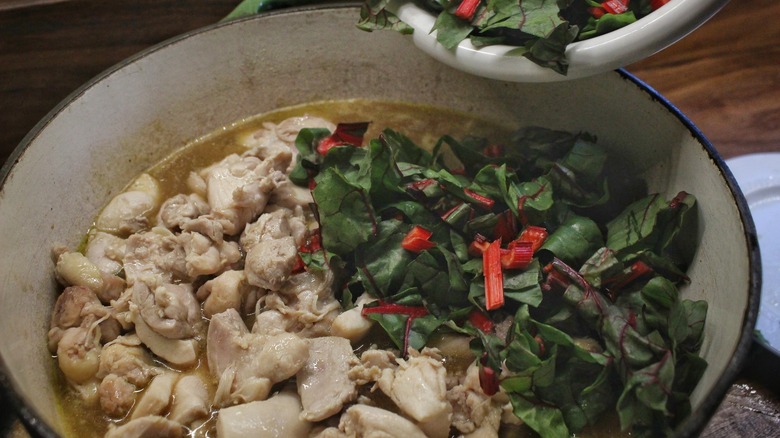 chicken and greens in soup pot