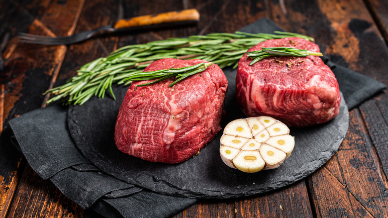 Raw filet mignon steaks with garlic and rosemary