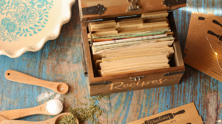 antique recipe box with cards and wooden spoons