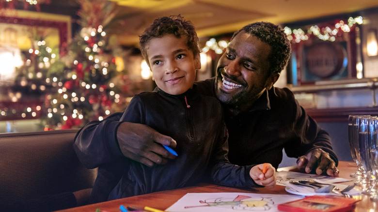 father and son in restaurant booth coloring with crayons