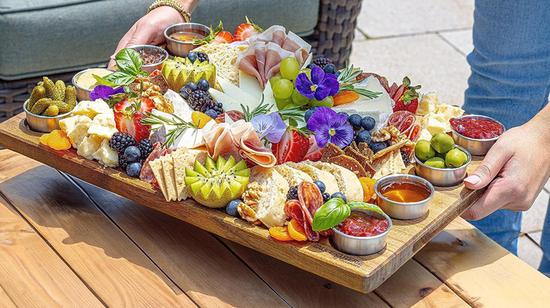Sauce-Cuteries wood charcuterie board with meat, cheese, fruit, flowers