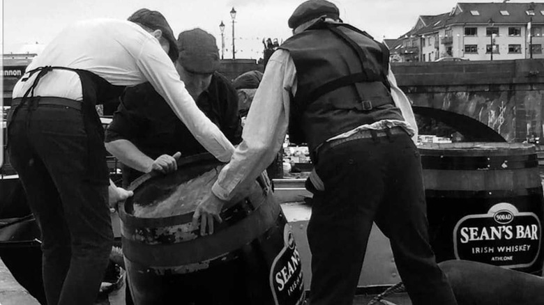 Sean's Bar employees wheel barrels of beer near river