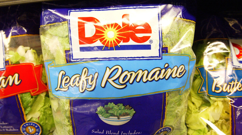 closeup of bag of salad greens on grocery shelf