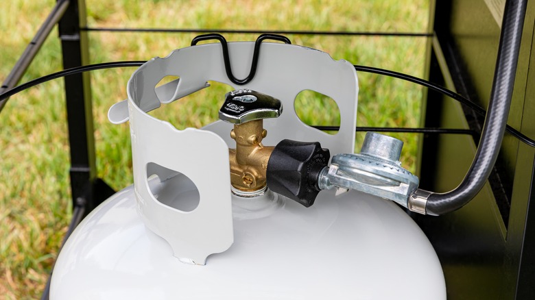 Close-up of grill propane tank and connection to grill