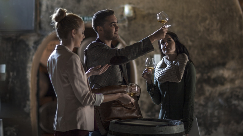 friends touring whisky distillery with whisky glasses