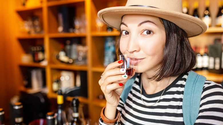 woman tasting whisky in shop