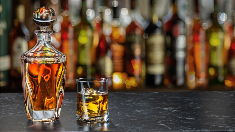 a whiskey decanter and glass on a bar