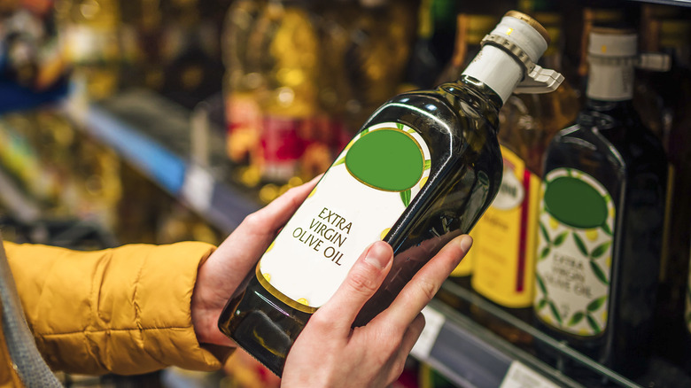 Person holding bottle of olive oil