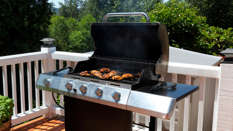 Food cooking on outside grill with lid open 