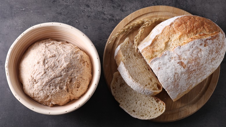 A bowl of uncooked sourdough sits next to a baked loaf cut into slices