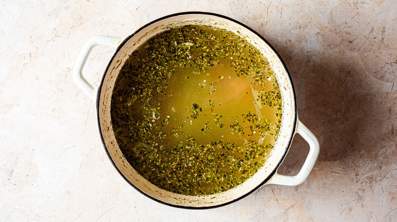 Pot of broth with rice and oregano