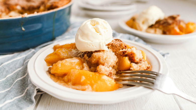 Peach cobbler on a plate with ice cream