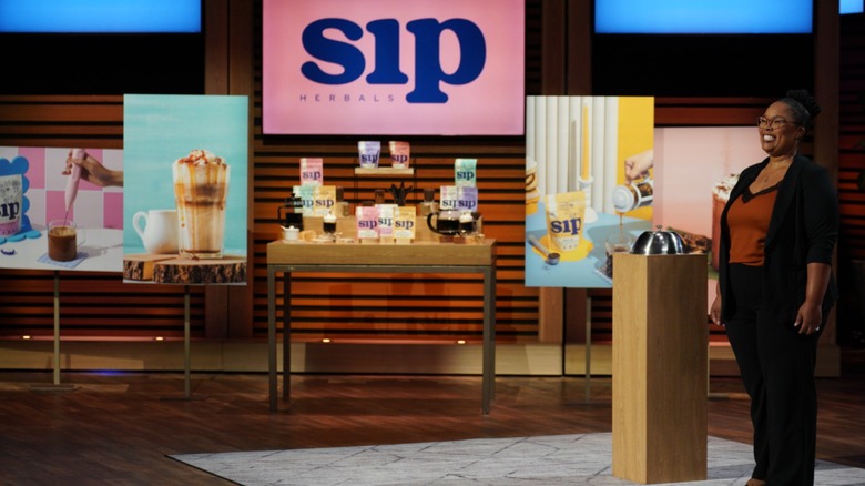 Orleatha Smith standing next to packets of Sip Herbals on Shark Tank