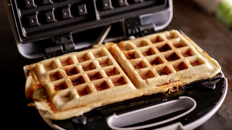 stuffed square-shaped waffles sitting in an open waffle iron