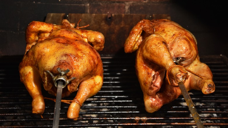 Rotisserie chickens cooking on the grill