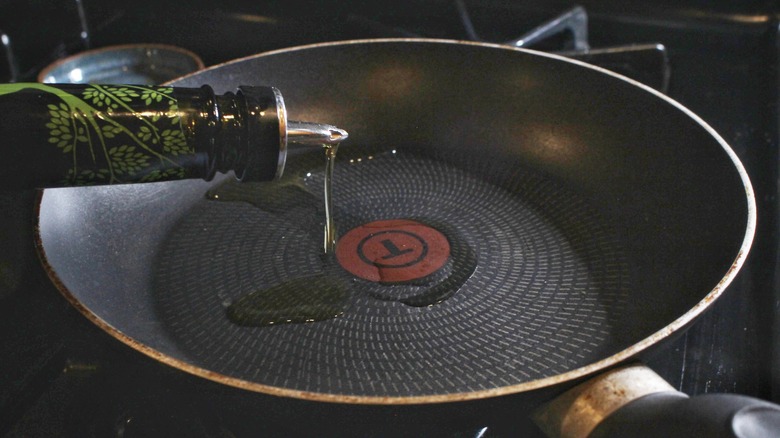 pouring oil into skillet