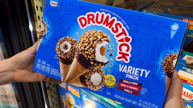 A person holding a variety pack of Nestlé Drumsticks