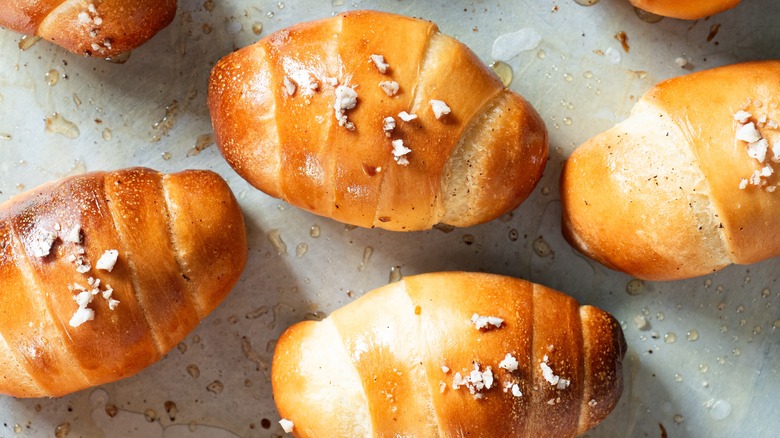 Salt bread rolls on greased surface