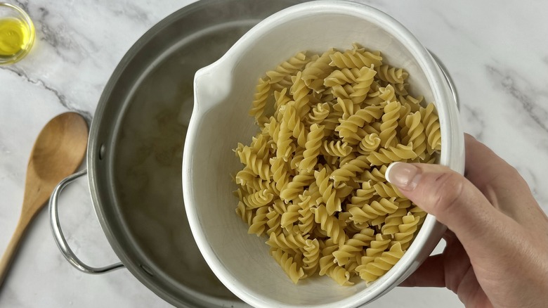 hand holding pasta over water