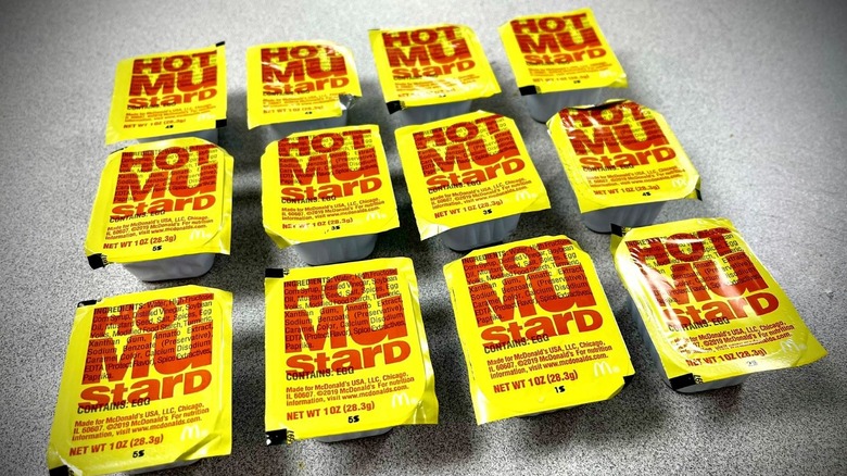 McDonald's Hot Mustard dipping sauce rectangular cups with yellow and red sealed covers lined in up three rows of four