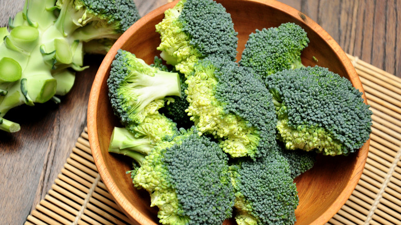 Wooden bowl of broccoli florets freshly cut from the stalk