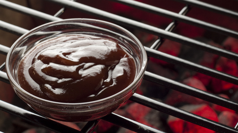 Bowl of barbecue sauce on grill