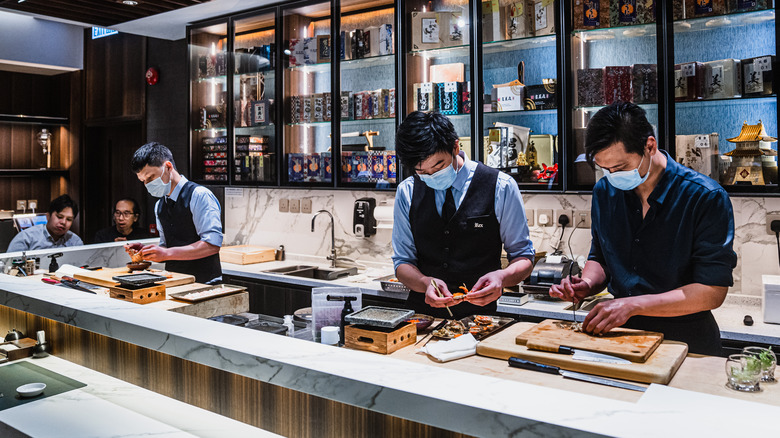 Chefs handling fish at restaurant