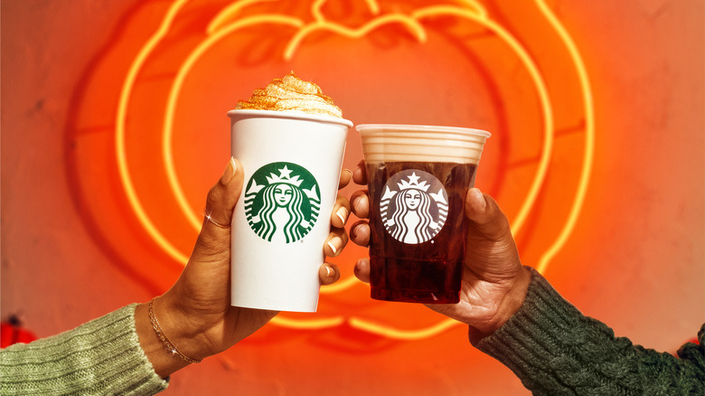 People holding Starbucks drinks