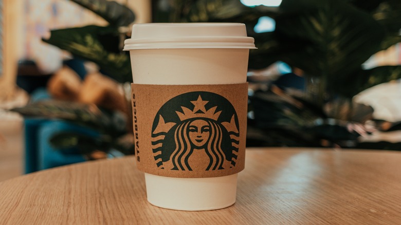 a starbucks coffee cup on a wooden table