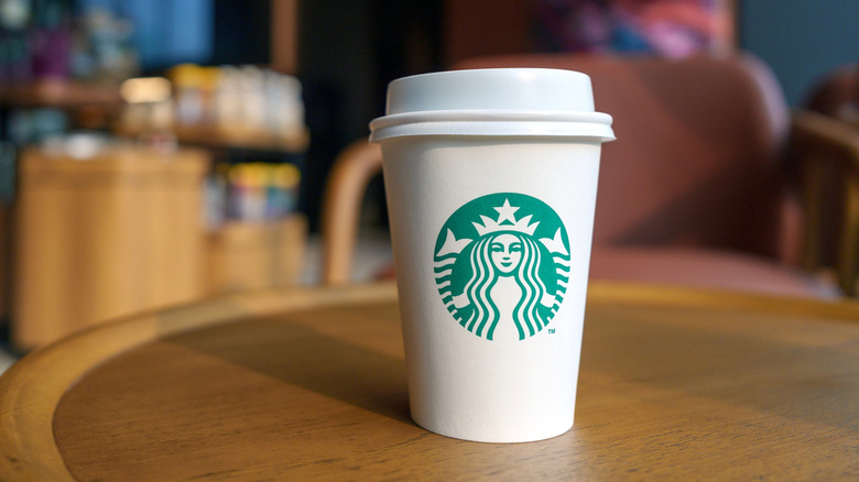 Hot Starbucks cup on table in cafe.