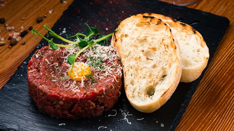 Steak tartare topped with egg yolk with toast