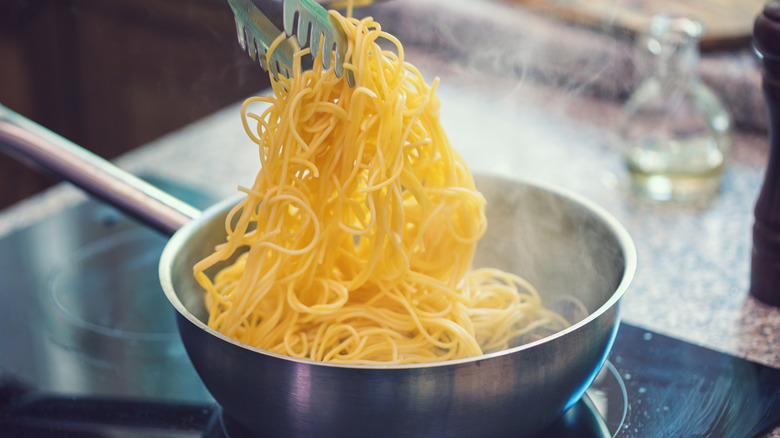 Adding spaghetti to a pan