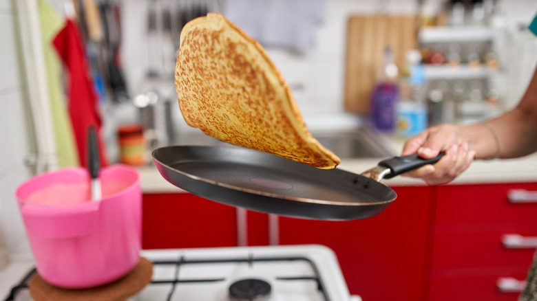 Person flipping pancake with no hands