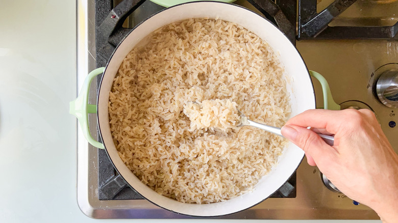 Fluffing rice in pot with fork