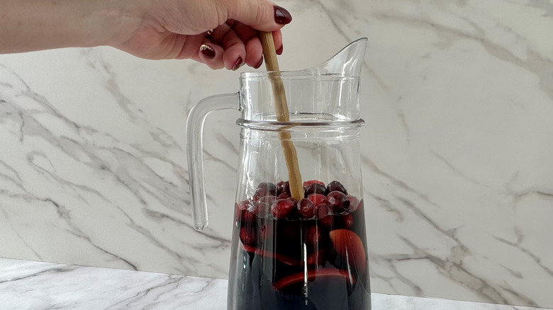 Hand stirring sangria with a wooden spoon