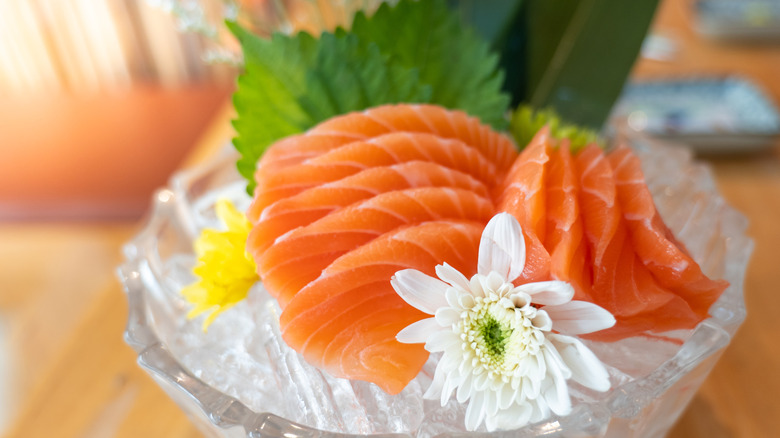 A bowl filled with ice and salmon sashimi