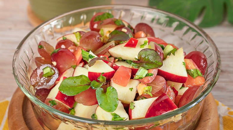 Grape salsa with chopped apples and herbs in glass bowl