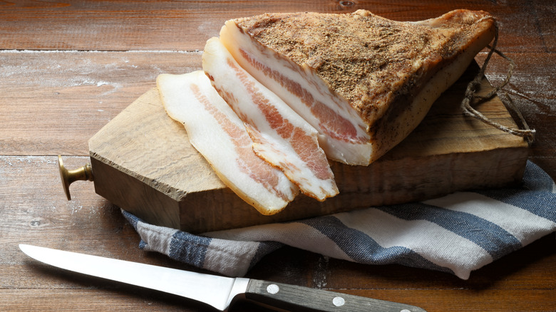 Guanciale sliced on wooden board