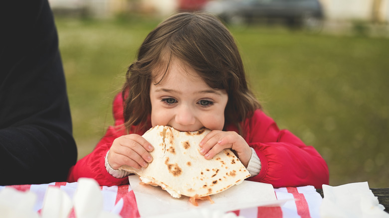 small child eating pita bread